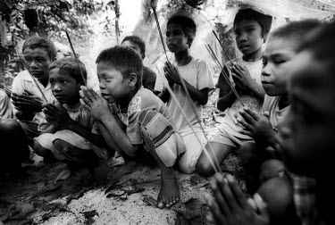 Moken children praying in the village cemetery. They are an animist, nomadic tribe of sea gypsies, numbering some two hundred, who live on Mu Ko Surin island off the western coast of Thailand. Scienti...