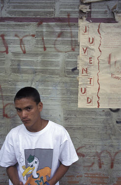 Bayron next to a poster which says 'juventud' - 'youth' - in Barrio Caicedo.