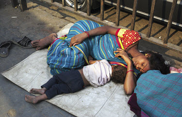 A homeless woman and her child sleeping in the street.