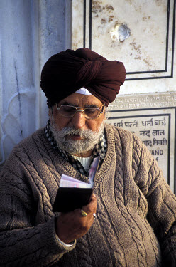 Worshipper reading a religious text in the grounds of the Golden Temple, also known as Harmandir Sahib, which is the sacred home of the Sikh faith.