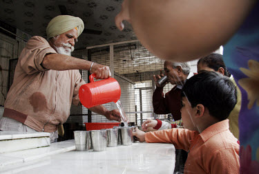 A man providing water to worshippers outside a Sikh temple in Old Delhi.