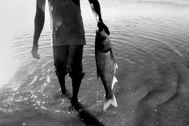 A fisherman holds a 3kg fish.