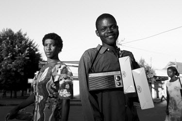 A young man selling cheap radios in the street.