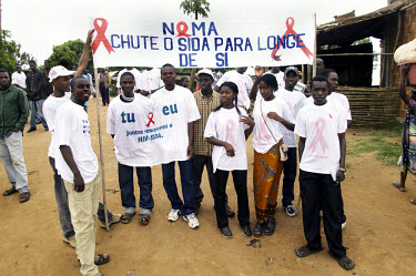 Students wait to participate in a parade for International AIDS Day. Their banner reads 'Give AIDS a kick in the ass'.