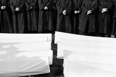 A line of imams pray as the bodies of forty Muslims  are prepared for reburial after being exhumed. The village of Visoko was ethnically cleansed in 1992, and most of the menfolk were shot on their do...