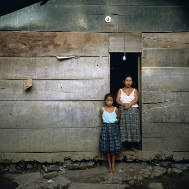 Mother and daughter at the door of their home.