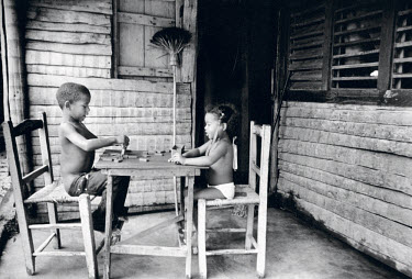 Siblings Lester Sosa (6) and Lucy (4) playing dominoes.