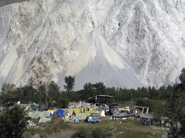 A landslide brought down the entire side of a mountain during the earthquake which struck Pakistani-administered Kashmir on 08/10/2005. Survivors' tents populate the valley floor. At least 40,000 peop...