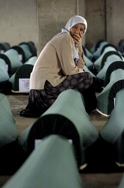 A woman mourns among the nearly 600 coffins that were placed in the battery factory in Potocari in preparation for their burial on the 11th July, the tenth anniversary of the Srebrenica massacre. An e...