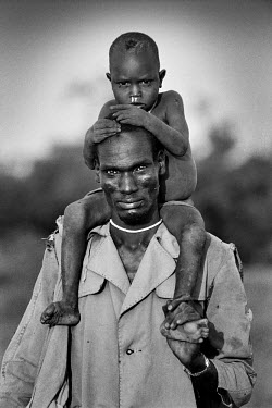 A Dinka tribesman flees with his son through the swamps near Nasir as the civil war rages on.