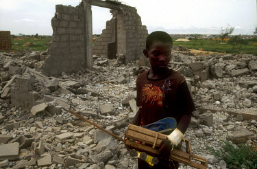 A young boy in the ruins of his home in the middle class area known as Golfe 2. In December 2002, men, presumably from the government, forcibly demolished privately owned homes on this land. The land...
