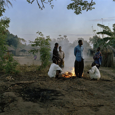 Men from the village stand around a fire that warms them in the cold early morning air.    The village of Dickson contains 55 households and some 300 inhabitants. In 2005 photographer Jan Banning and...
