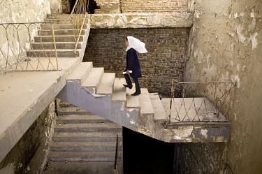 A schoolgirl walks up a flight of steps in the Old Kabul Theatre, a building which has been destroyed by decades of war.  The abandoned building serves as as a school space for young girls eager to re...