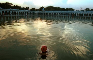 A worshipper bathes in a lake inside a Sikh temple.