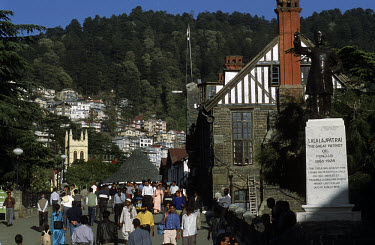 Middle class Indians walk along a street on the ridge with Christ Church in the distance. This hill station in the Himalayas was formerly the summer capital of India during the Raj era.