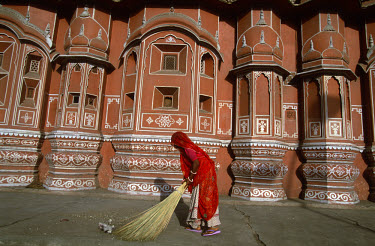 A Dalit (untouchable) street sweeper at work in front of the Hawa Mahal, the Palace of the Winds.