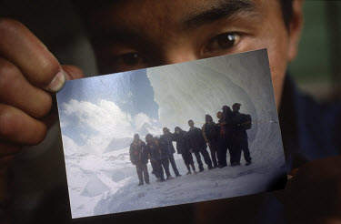 A newly arrived Tibetan refugee at the Tibetan refugee reception centre in Dharamsala shows a photograph that he took of his group during their flight from Chinese controlled Tibet, walking over the H...
