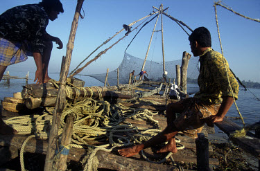 Fishermen waiting to raise Chinese fishing nets at Fort Cochin.