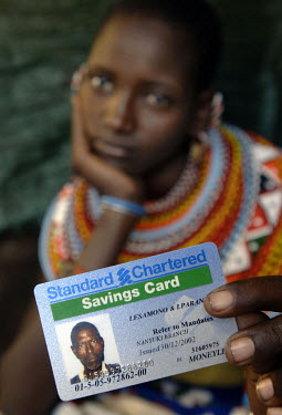 Regina Mantaine with her husband Kitako Lesamana's Standard Chartered bank savings card. Kitako received compensation from the British government as one of 233 Masai tribespeople killed or maimed by m...