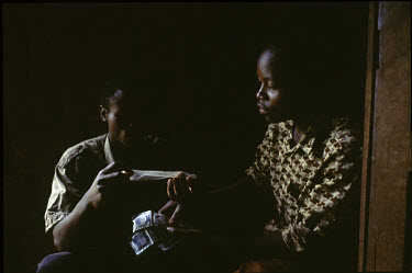 Emmanuel Singizumakiza (L), a health educator shows a boy how to use a condom.