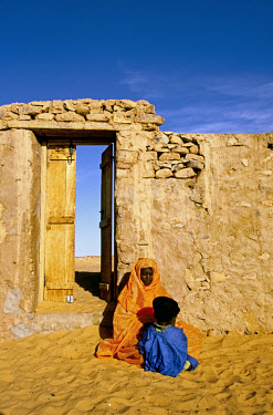 Woman and her child beside a doorway.