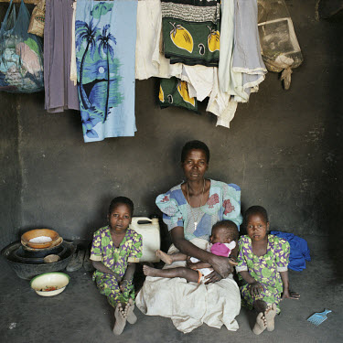 Marieta Simenti sits underneath her washing line in her house with her daughters Letina, Kelementina and Msakila.