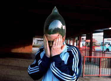 Tompa peforms his trick of inflating a condom over his head, while hanging out with friends at the local bus station.  'All Dressed up' is a series exploring how various groups of teenagers socialise...