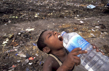 8 year old Jahangir pauses for a drink while collecting rubbish on the Kajla rubbish dump.  It is one of three landfill sites in this city of twelve million people.   Around 5,000 tonnes of garbage ar...
