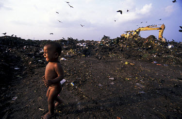 A child cries for its mother who works scavenging among refuse on the Kajla rubbish dump.  It is one of three landfill sites in this city of twelve million people.  Around 5,000 tonnes of garbage are...