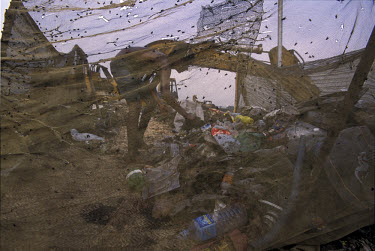Flies gather on a piece of netting as a boy scavenges among the rubbish on the Kajla rubbish dump for plastics and paper.  It is one of three landfill sites in this city of twelve million people.  Aro...