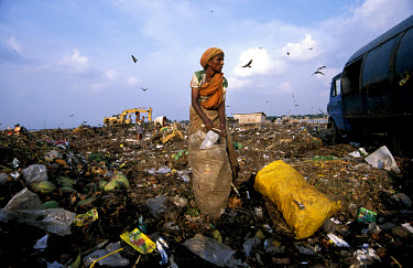 A woman stands among the refuse with a sack filled with plastic bottles she had collected on the Kajla rubbish dump.  It is one of three landfill sites in this city of twelve million people.  Around 5...