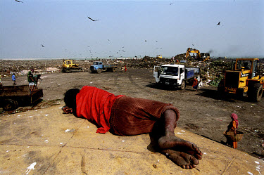 14 year old Kakon takes a nap on the roof of a rubbish truck overlooking the lorries and hydraulic diggers on the Kajla rubbish dump.  It is one of three landfill sites in this city of twelve million...