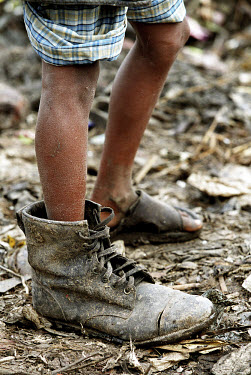 8 year old Alamin wears a policeman's shoe, which he has found among the piles of waste on Kajla rubbish dump.  It is one of three landfill sites in this city of twelve million people.  Around 5,000 t...