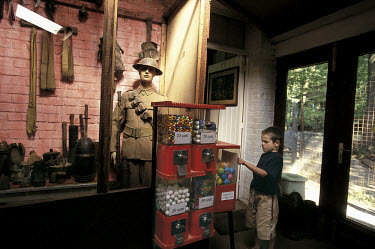 A boy uses a vending machine in the sanctuary wood museum, which displays military gadgets and war paraphernalia from World War One (WWI).