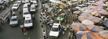 Taxis and minibuses form traffic jams at the Gajah Mada and Hayam Wuruk junction where a market operates under a canopy of coloured umbrellas in the road in the Chinese quarter of the city.