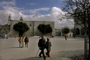 Palestinians walk in Manger Square, with the Church of the Nativity on the left.