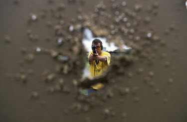 A private security guard practices shooting at a gun range.