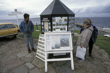 Tourists views work by a signpost photographer who takes photographs of visitors to Britain's southernmost point.