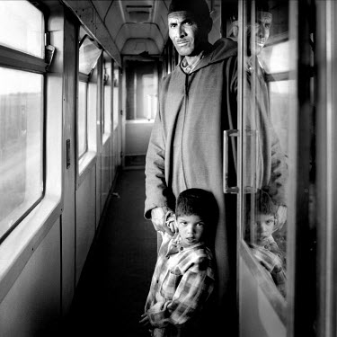 Father and son in the corridor of a train carriage.