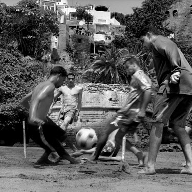 Young men playing football at Oudallas Wall.