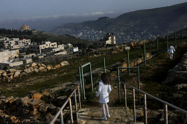 Two Samaritan girls running to their village (at left) on Mount Gerizim, overlooking the Palestinian city of Nablus. The religion of Samaritanism is based on the Torah. Samaritans descended from the a...
