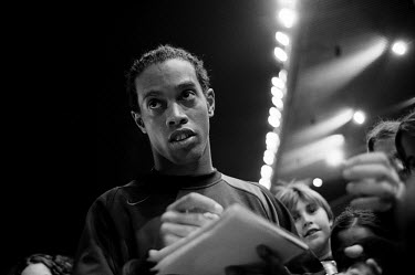 FC Barcelona football player Ronaldinho signs autographs for children during a teaching session conducted by the team.