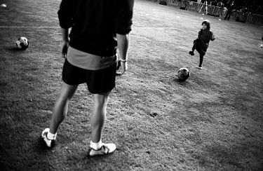 A little girl kicks a ball to FC Barcelona football captain Carles Puyol during a teaching session conducted by the team.