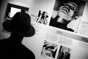 A visiter to the Hiroshima Peace Memorial Museum looks at photographs of some of the victims of the atomic bomb which struck the city in World War II (WW2).