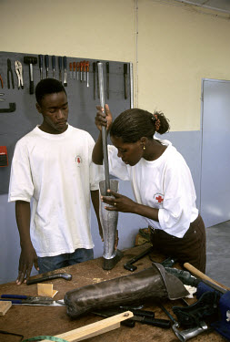 Members of the Mozambican Red Cross make a prosthetic leg for landmine victims in an orthopaedic workshop.