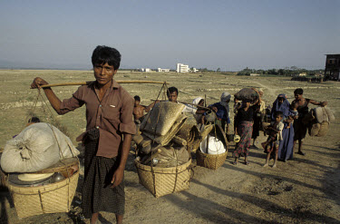 Burmese Muslim refugees carry their belongings in baskets.