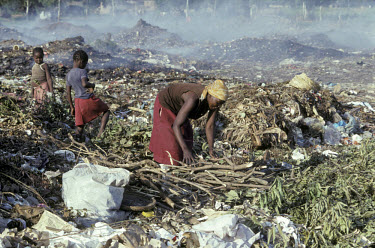 Woman with her children searching the city rubbish dump for firewood and recyclables.