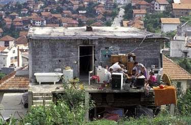 Family eating lunch on the terrace of their half-built home in a suburb of the city.