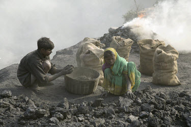 Workers collecting coal for resale on a small coal dump. Most of the workers have migrated to the area having been displaced from their traditional livelihoods in the countryside. Lacking title deeds...