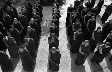 Exiled Tibetan nuns stand in lines in the courtyard of a convent.